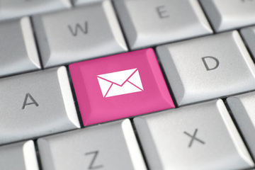 computer keyboard with a white envelope on a pink key on the keyboard